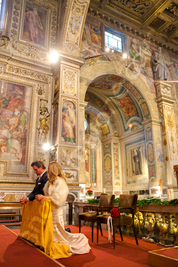 wedding-rome-3112-015 Bride and groom kneeling down by the alter during their wedding ceremony.