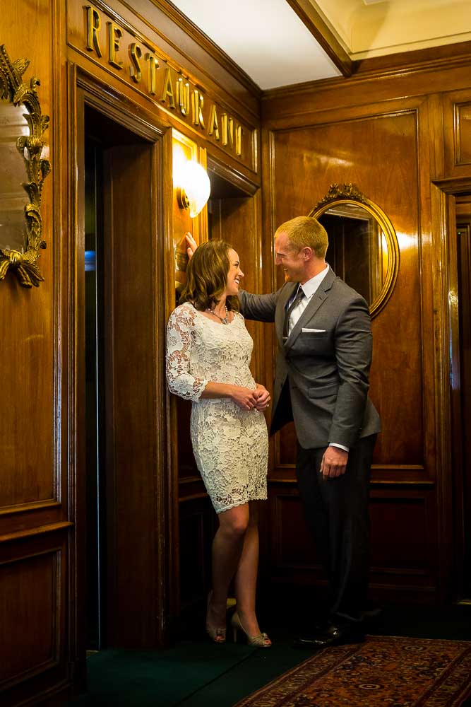 Closeup vertical shot of a couple inside a Hotel romantically standing by an elevator.