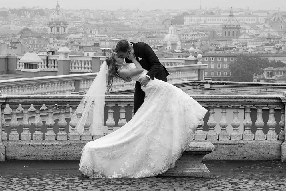 Groom dipping the bride overlooking the roman rooftops wedding picture 