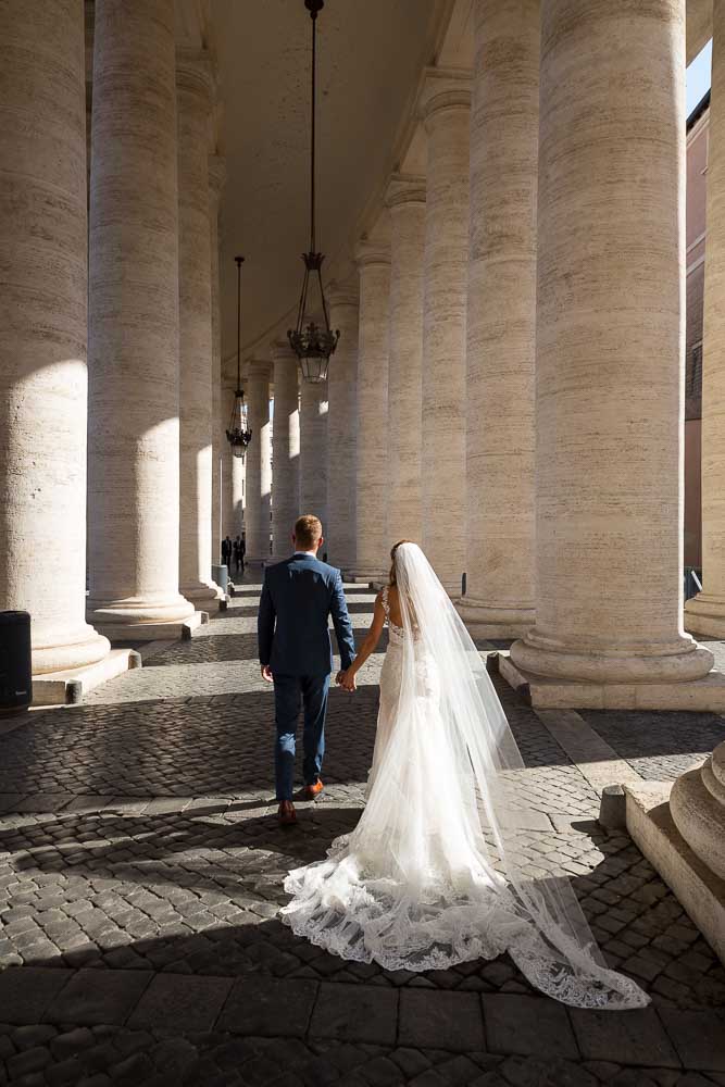 Walking underneath large marble columns Vatican