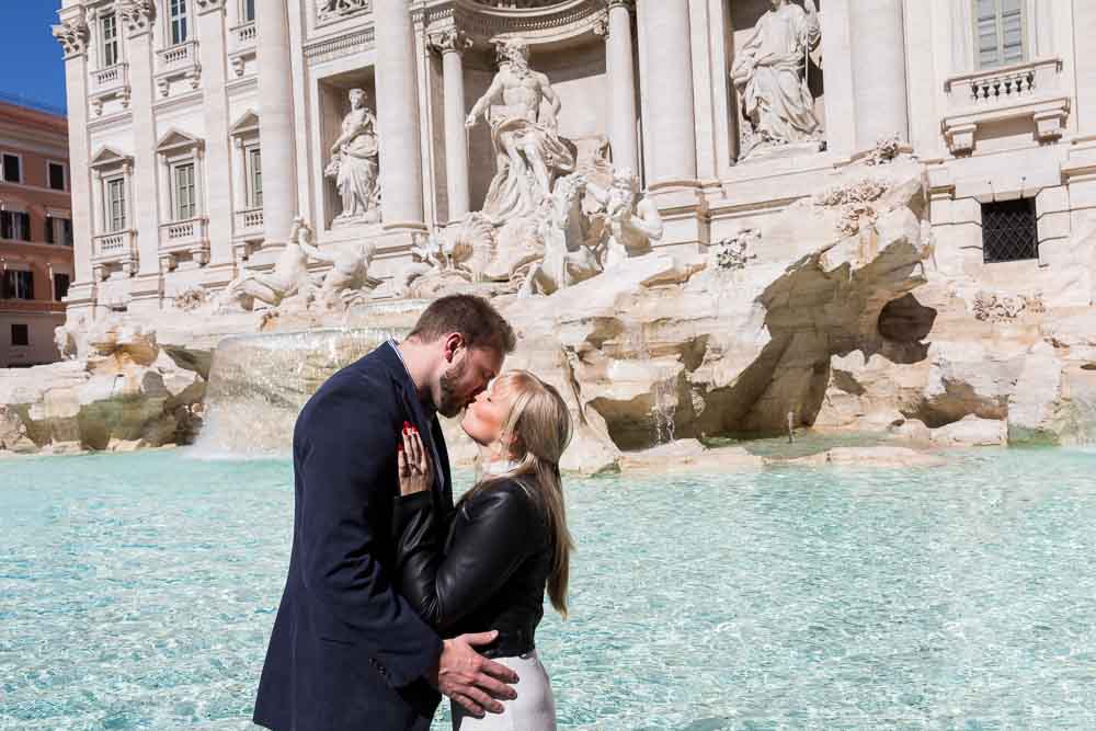 Kissing at the Trevi fountain during an engagement photo shoot 