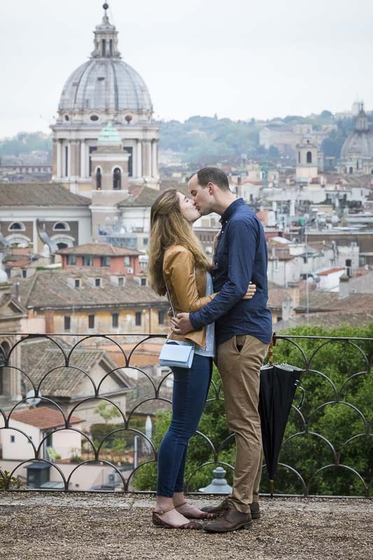 Kissing in love before the panoramic view roman rooftops