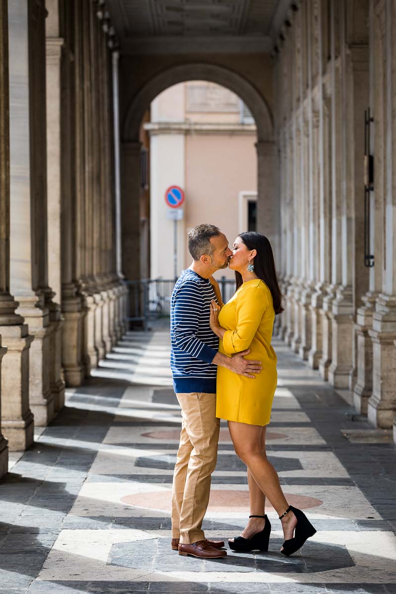 Kissing during a photo shoot in roman streets and portico