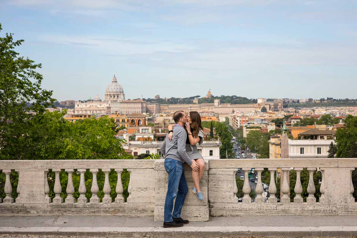 Kissing before the panoramic view of the roman city Italy as background