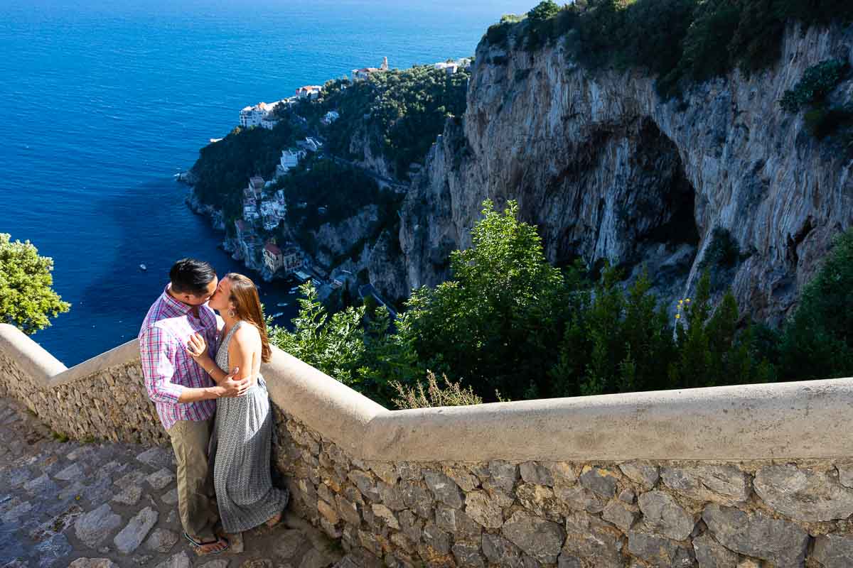 Couple kissing on a staircase before the coast view near the town 