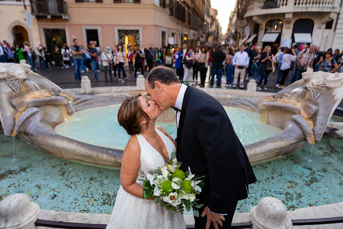 Couple kissing down below by the Barcaccia water fountain found at the bottom of the Spanish steps