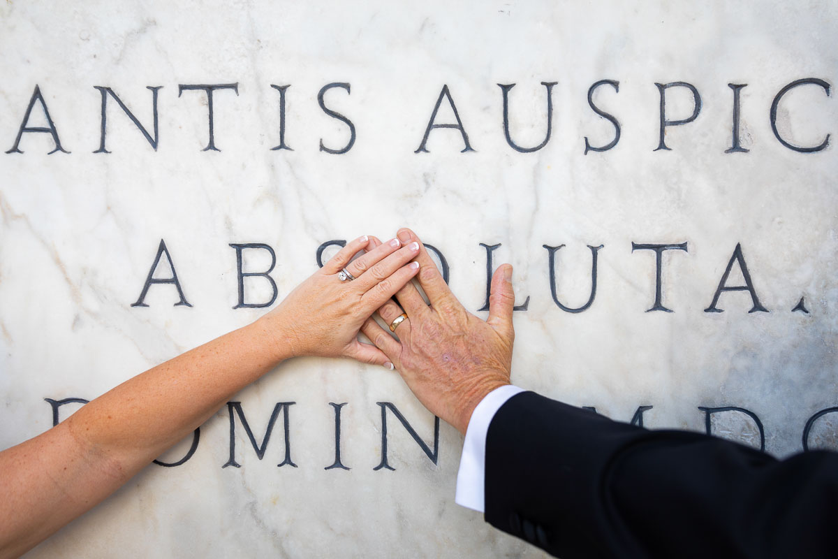 Just married in Rome. Wedding ring picture over ancient marble writing in Latin