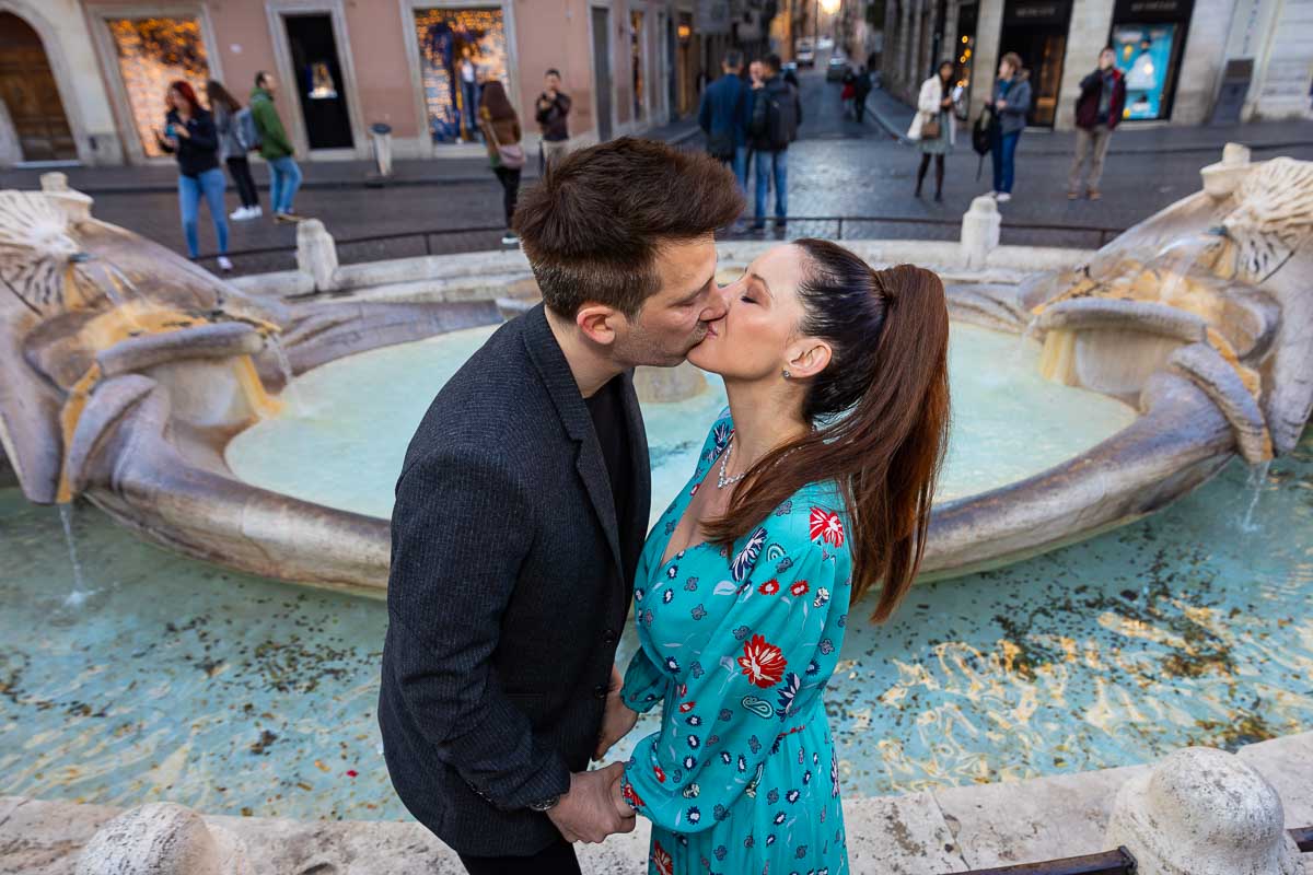 Kissing each other in front of the water fountain found at the bottom of the Spanish steps