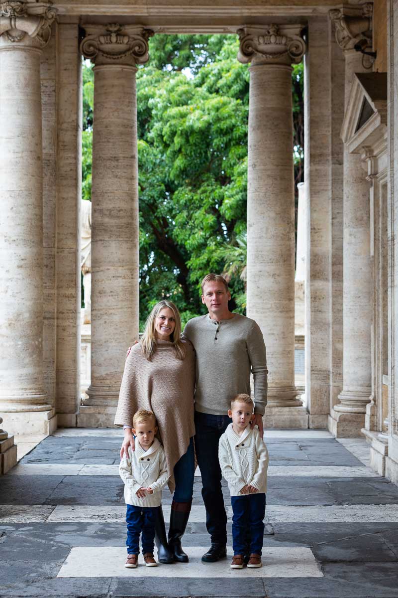 Taking photos underneath column porticos with green tree in the backdrop
