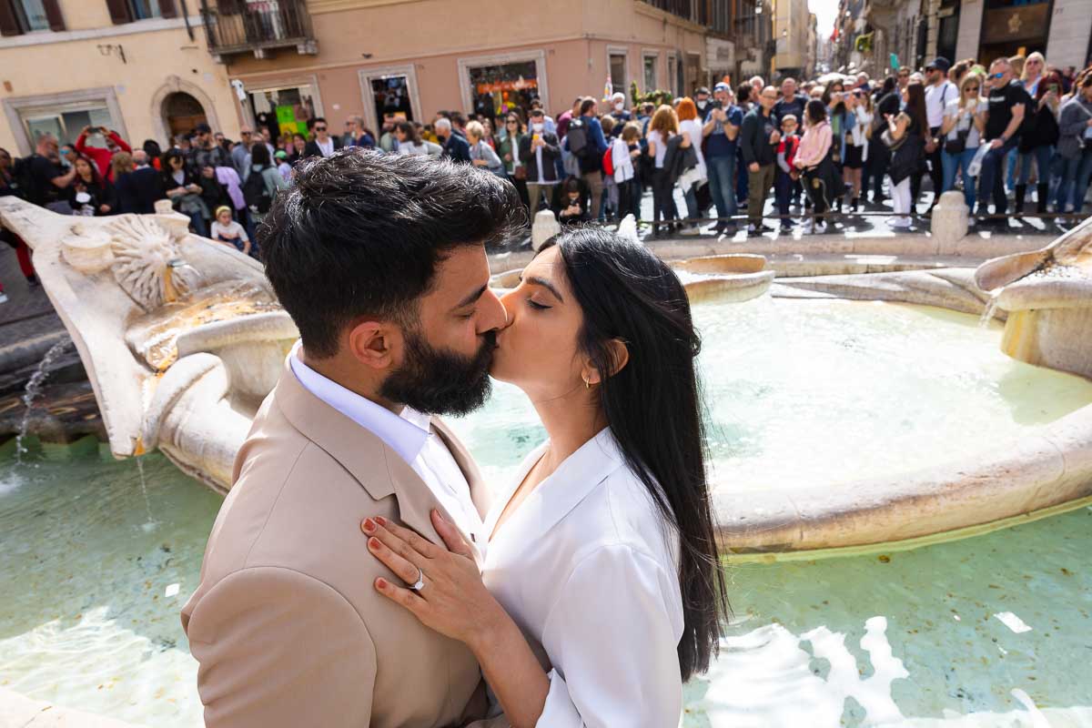 Couple kissing by the Barcaccia water fountain 