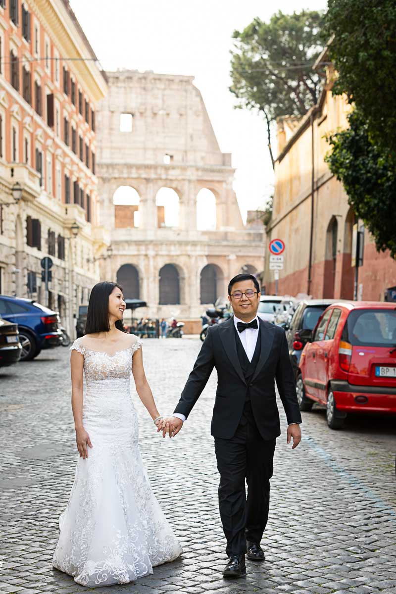 Couple just married walking hand in hand roman cobblestone streets and alleyways with a one of a kind background