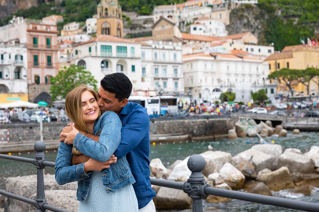 Together taking pictures on a pier overlooking the coastal town