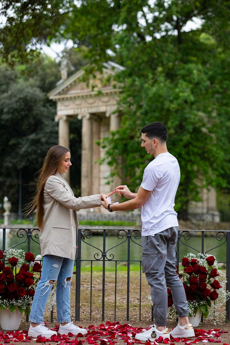 Just engaged near a lake with a view. Photographing the moment in which the engagement ring is being out on