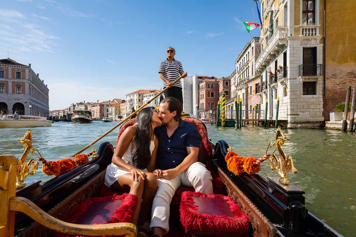 Kissing on a gondola ride on Canal Grande. Riding with a photographer to document the romantic proposal moment