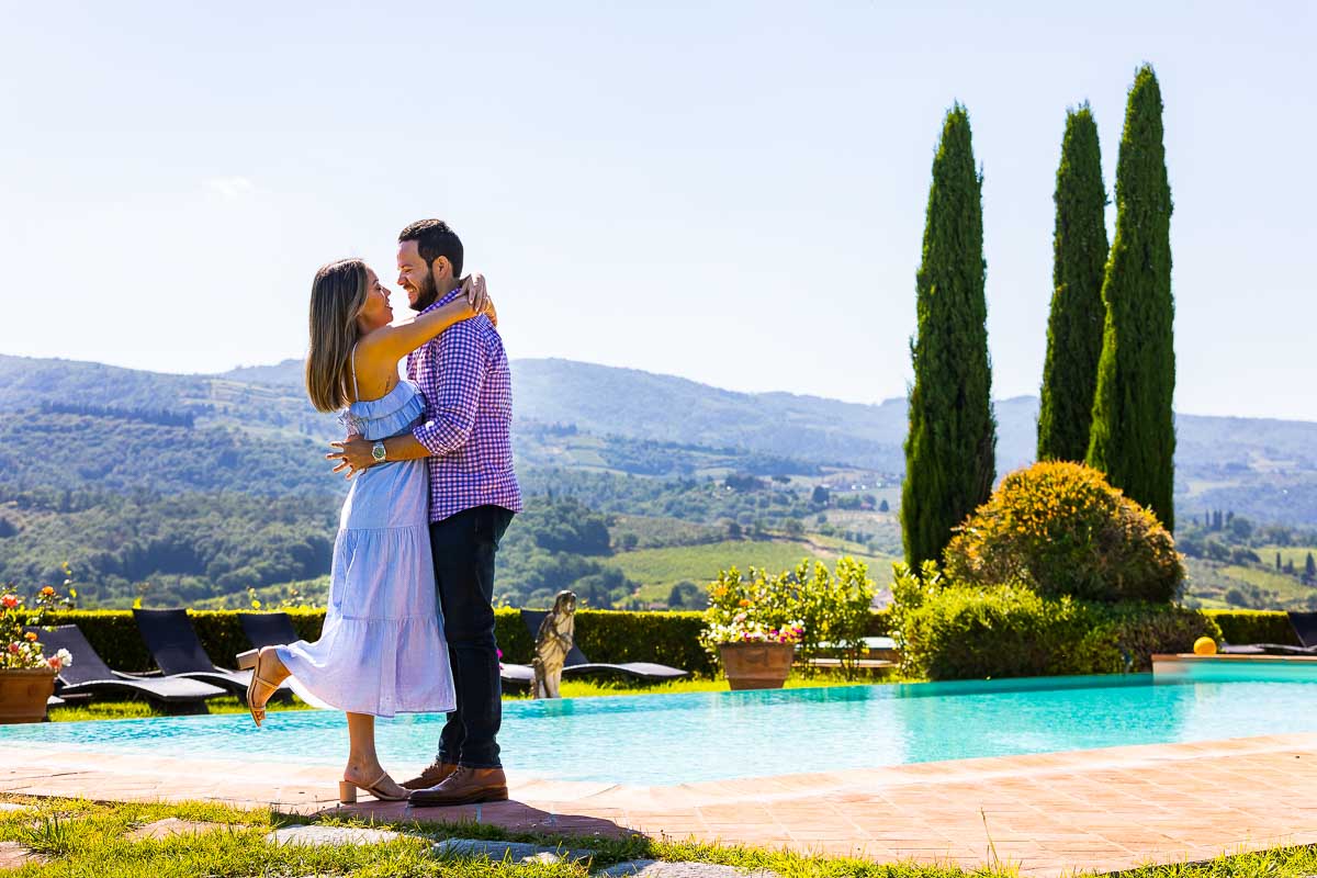 Coupe photography taken next to a swimming in Toscana during an engagement photo session