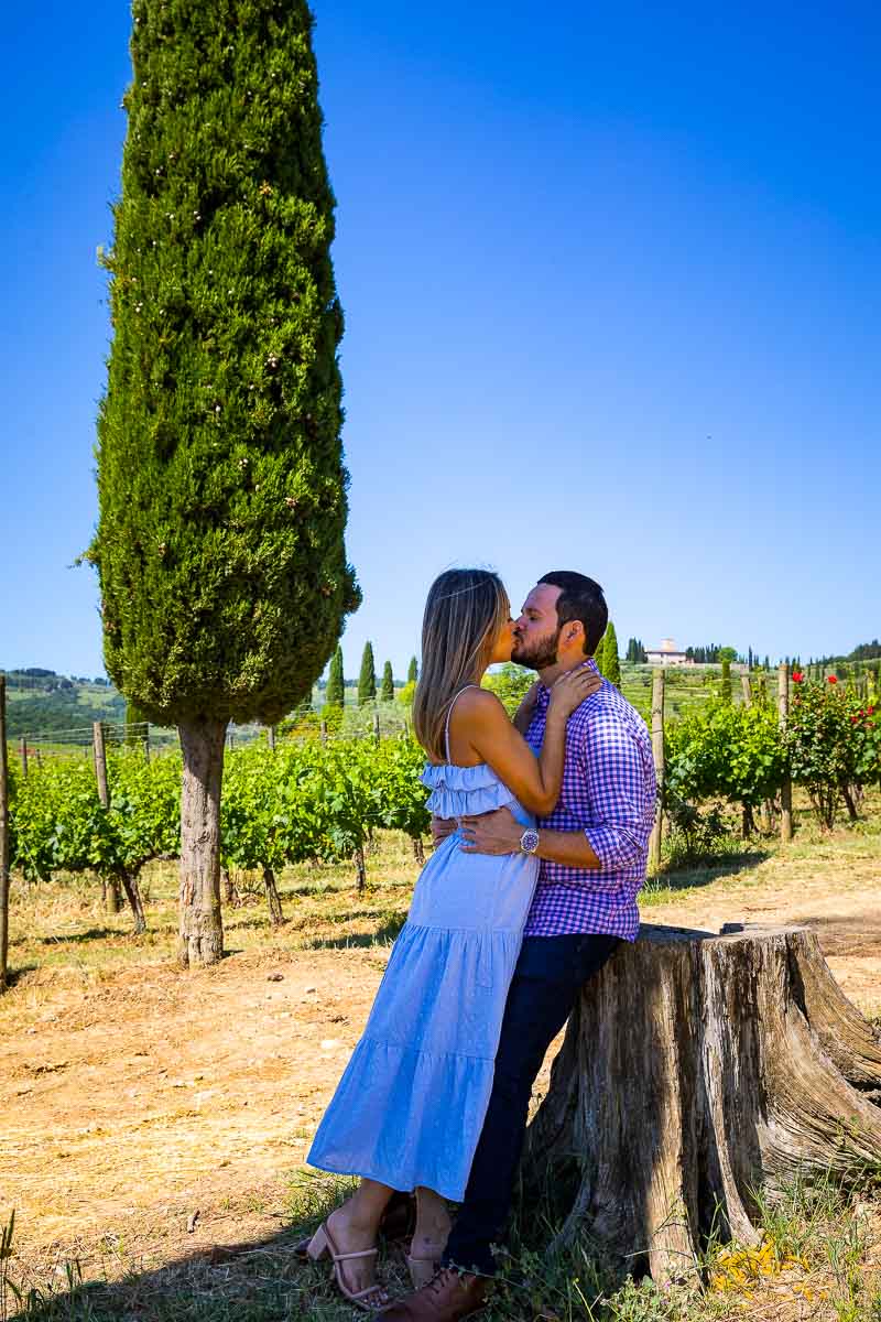 Typical Tuscan Couple Photography taken with vineyards and cypress trees background under a beautiful blue sky 
