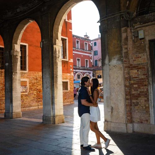 Couple posed underneath porticos during a photoshoot in Venezia Italy