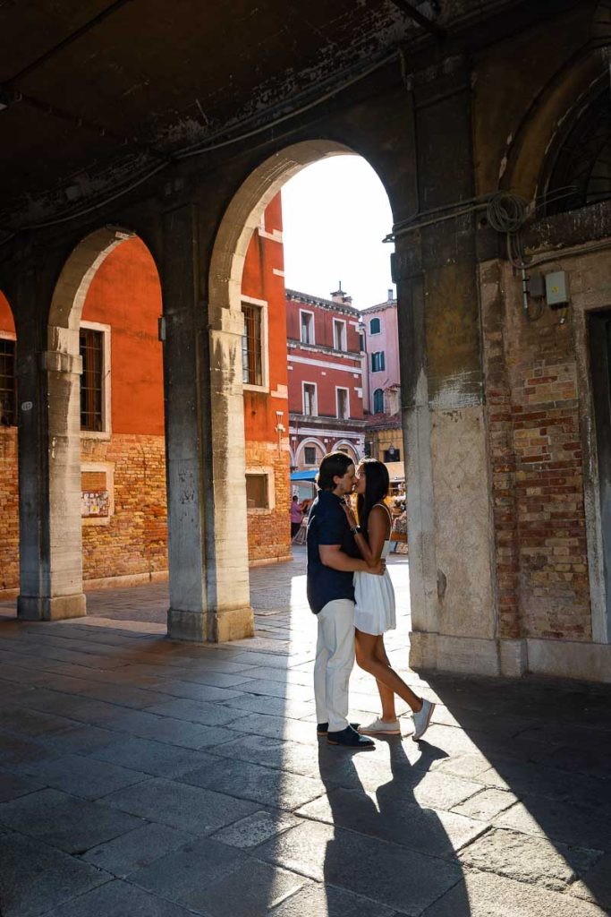 Couple posed underneath porticos during a photoshoot in Venezia Italy