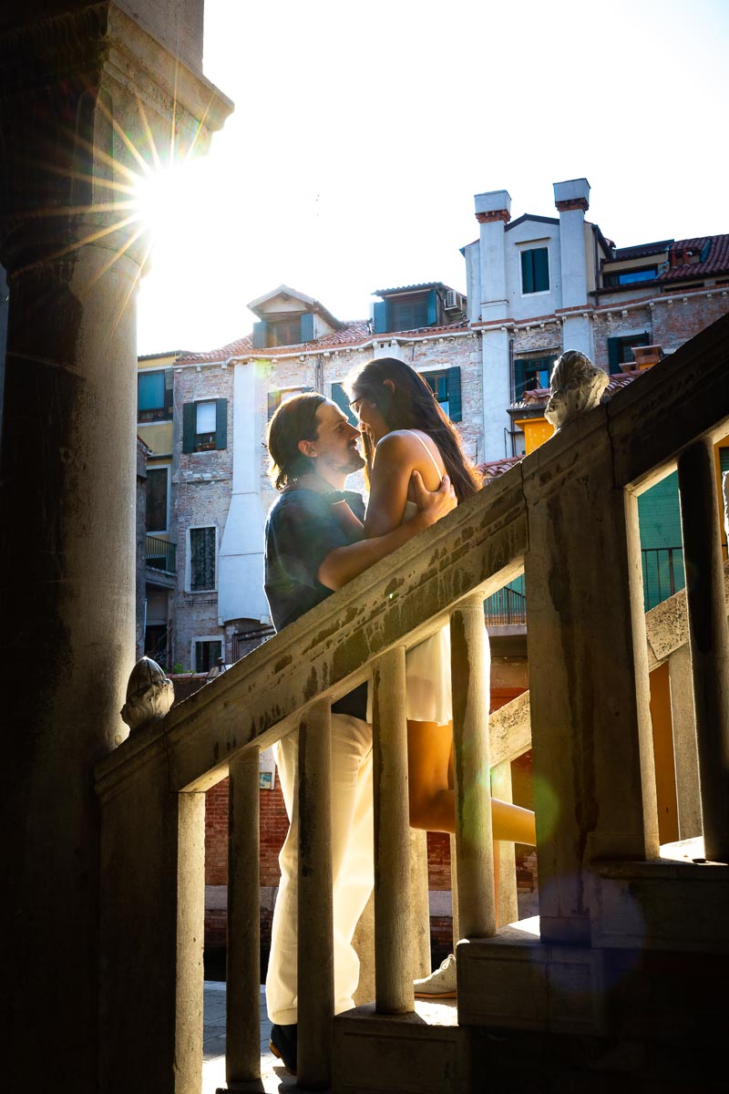 Final portrait picture of a couple standing on a staircase with the sun setting background