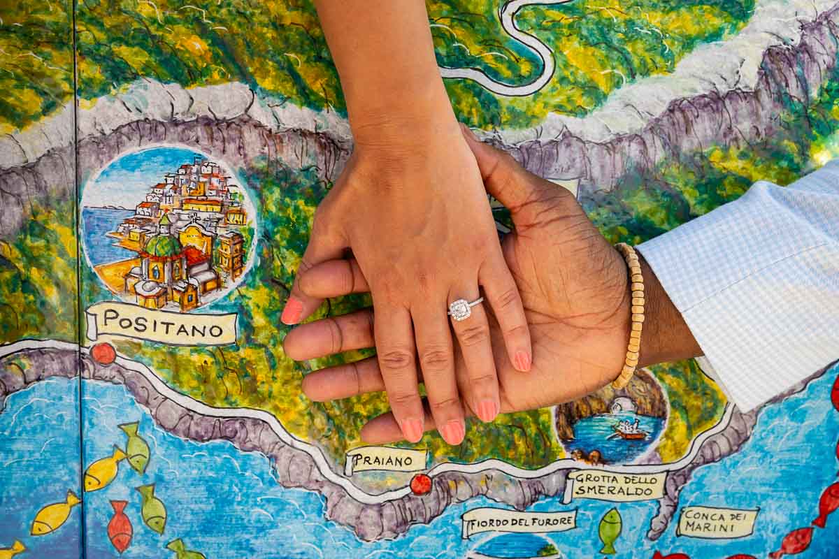 Closeup of the engagement ring photographed over a map coast in Italy