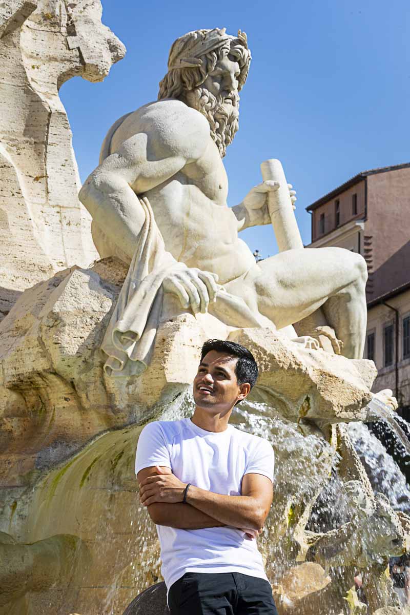 Male model posed portrait standing in front Fontana dei Fiumi in Piazza Navona a Roma