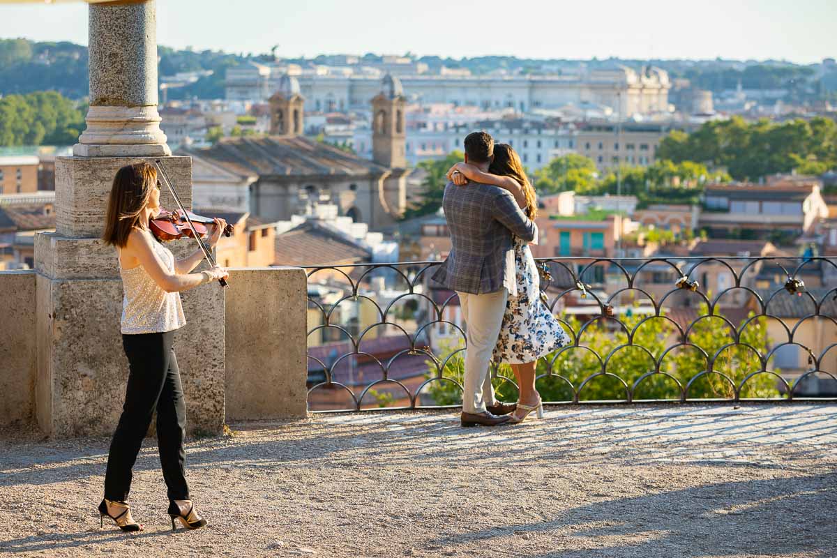 Violinist playing music during an engagement session photographed in overlooking the eternal city in Italy