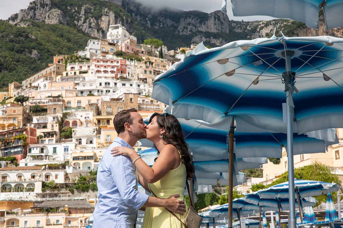 005-kissing-under-umbrella Kissing under the umbrella with the vertical town of Positano as backdrop