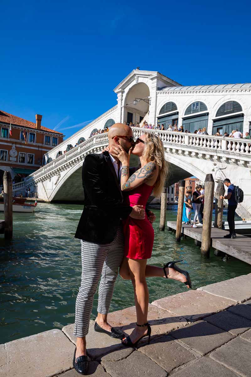 Couple posing and kissing in front Rialto bridge