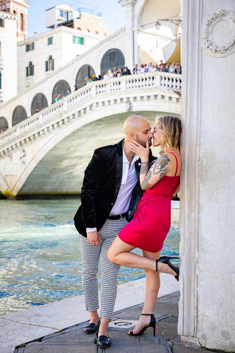 Leaning on the a side building holding a pose during a couple photoshoot with the Grand Canal background