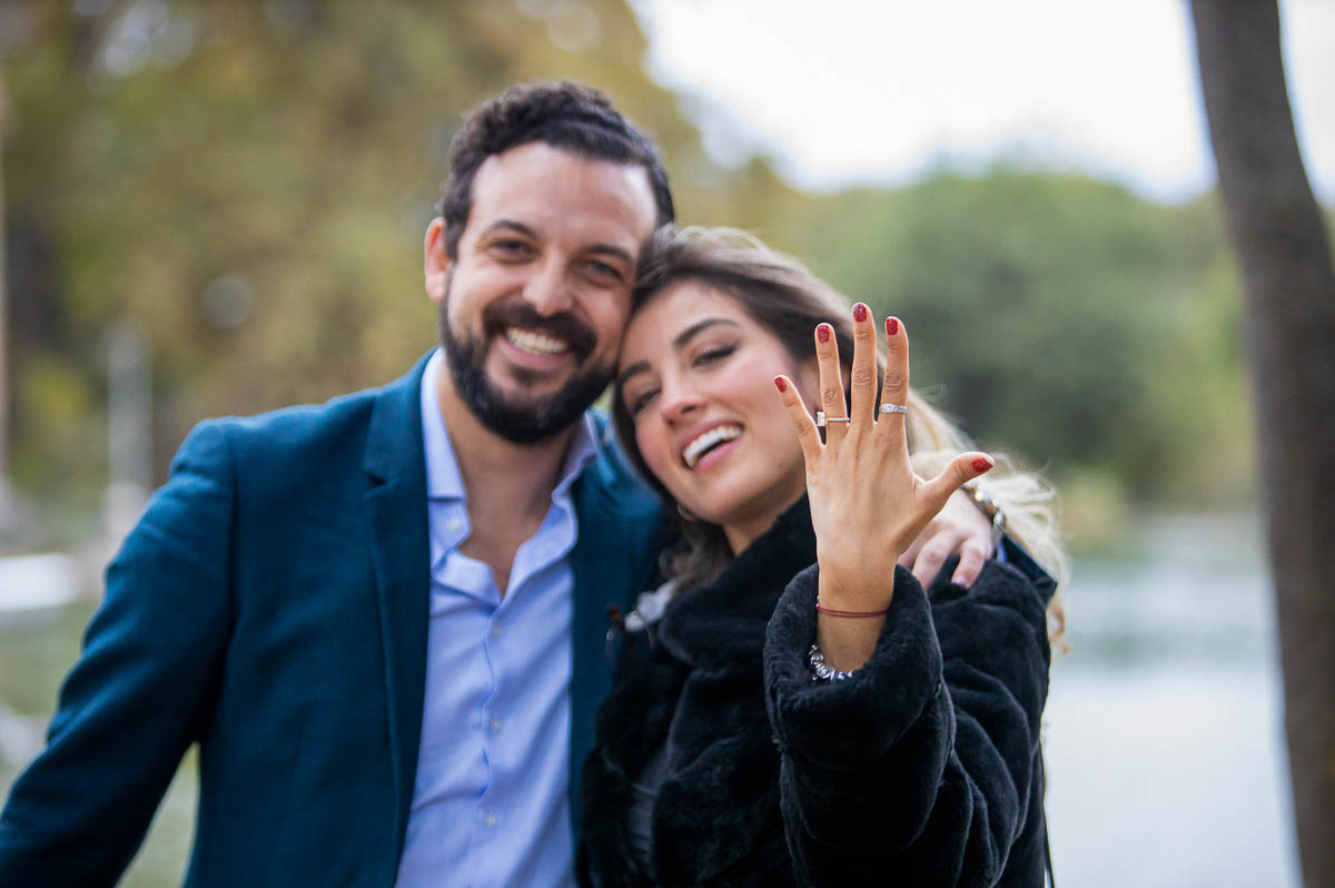 Couple holding up the engagement ring in celebration of newly engaged couple 