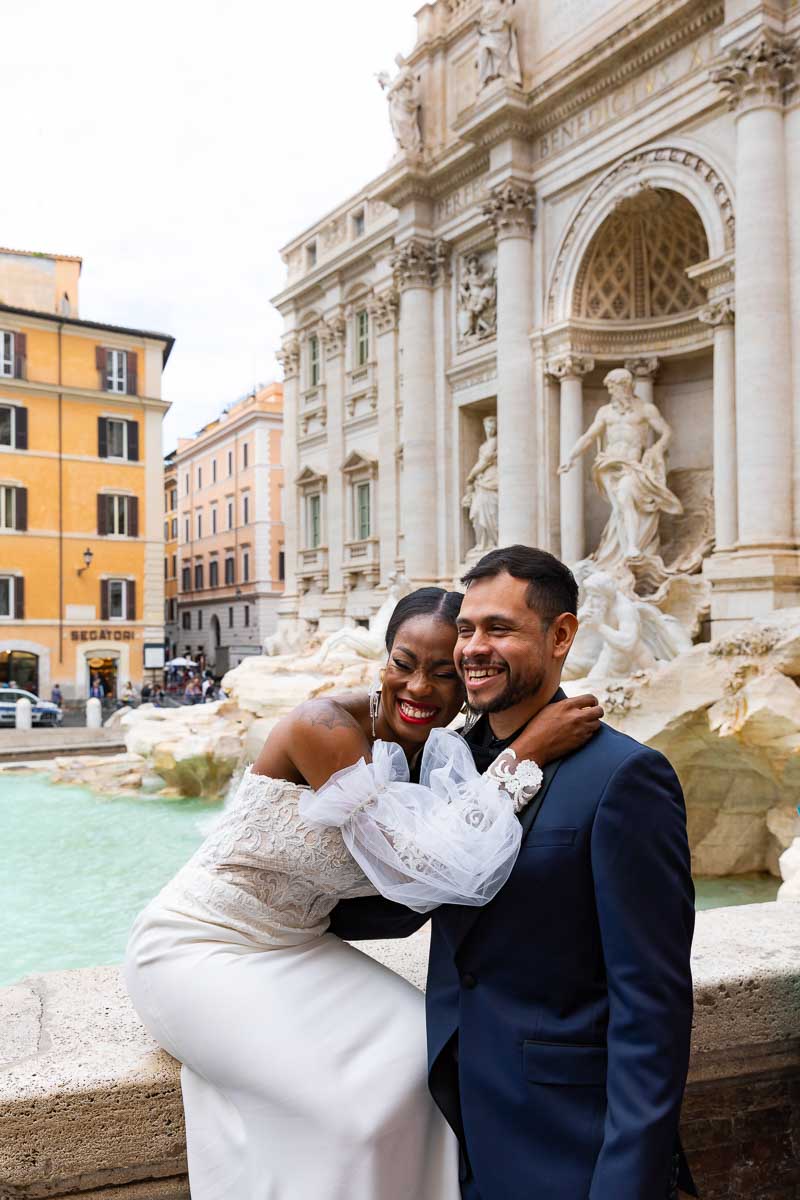 Laughing and having fun Trevi fountain during a photoshoot just married in Italy