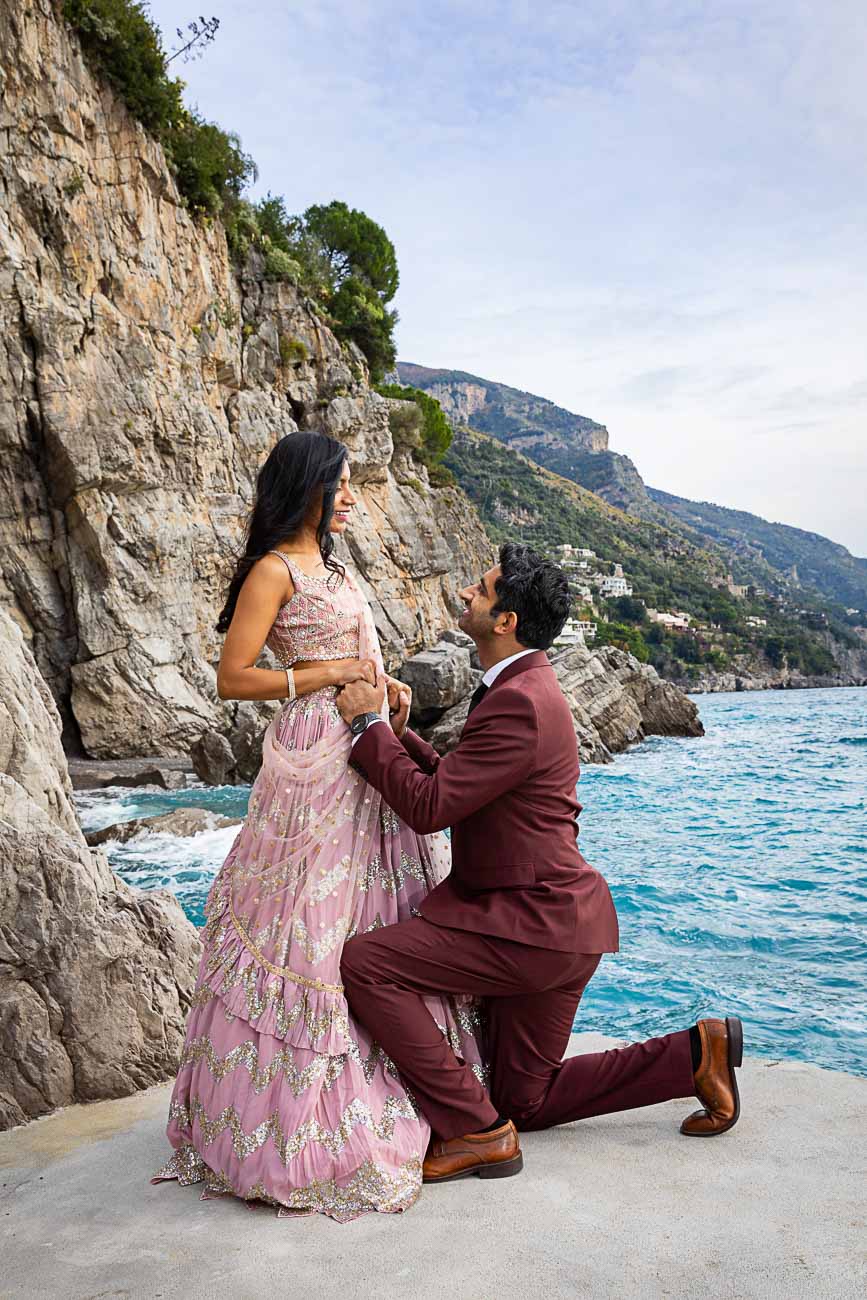 Knee down couple portrait with the Amalfi coast in the background