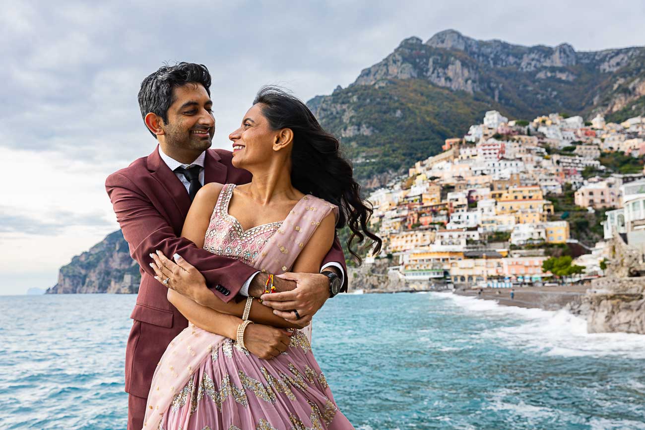 Couples Photo Positano. Bust up portrait picture. Posed beach with the town in the far distance