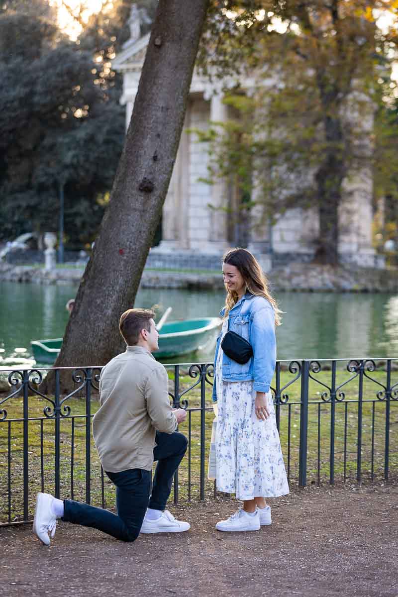 Surprise Wedding Marriage Proposal candidly photographed from a distance at the Villa Borghese lake Italy