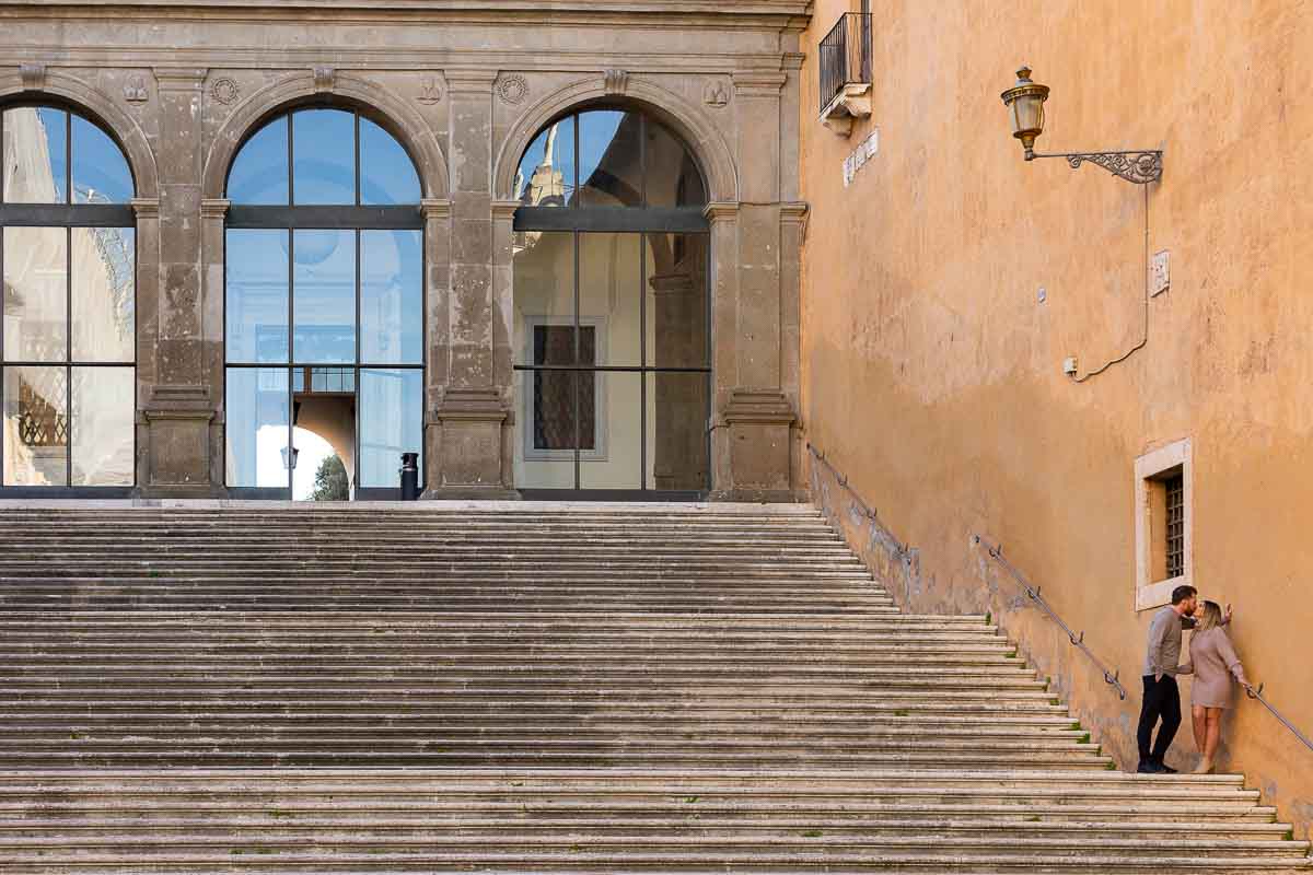 Artistic image of a couple standing on the staircase of Campidoglio square in Rome
