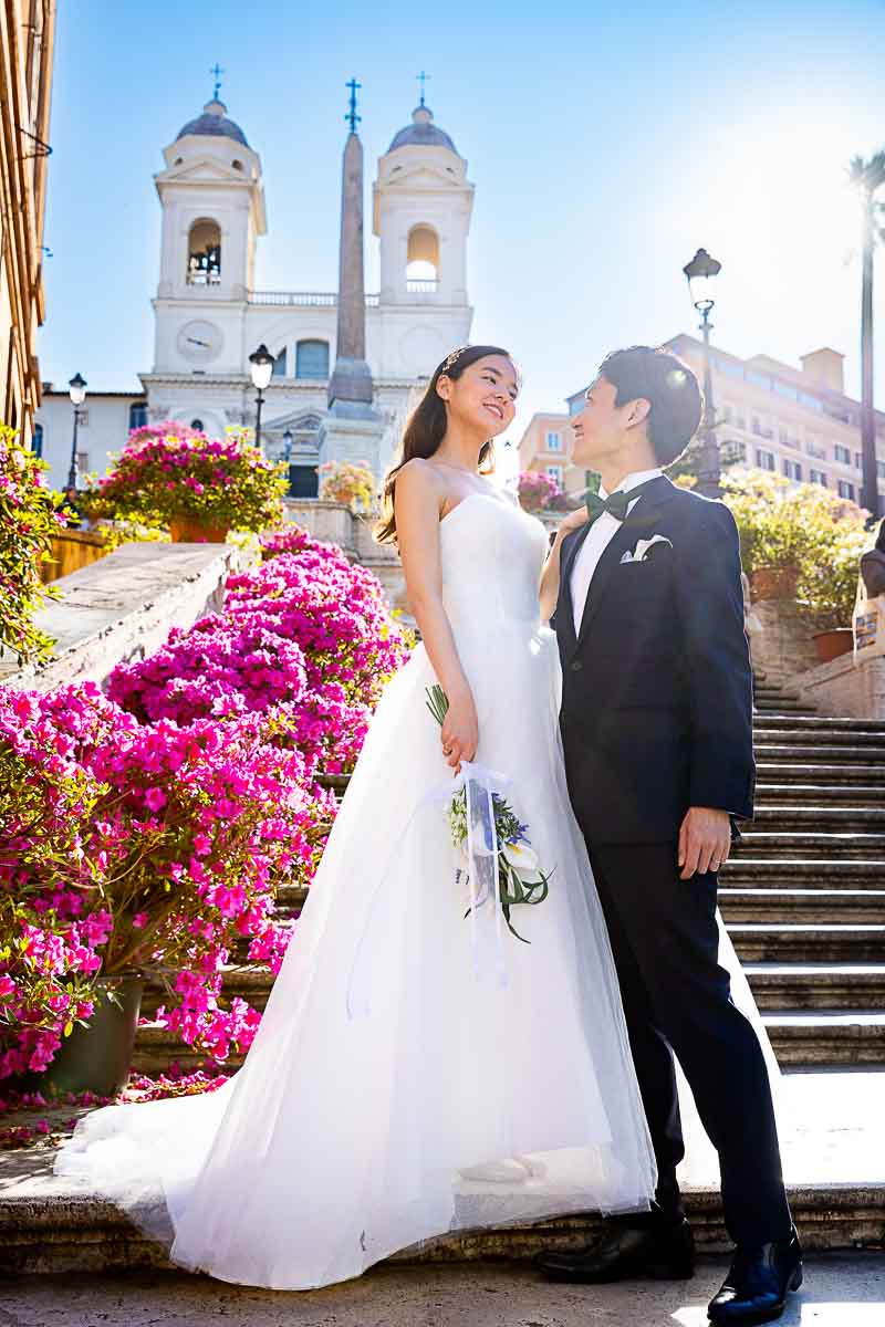 Groom and the Bride standing bottom Piazza di Spagna with all the flowers while posing for a wed photo shoot