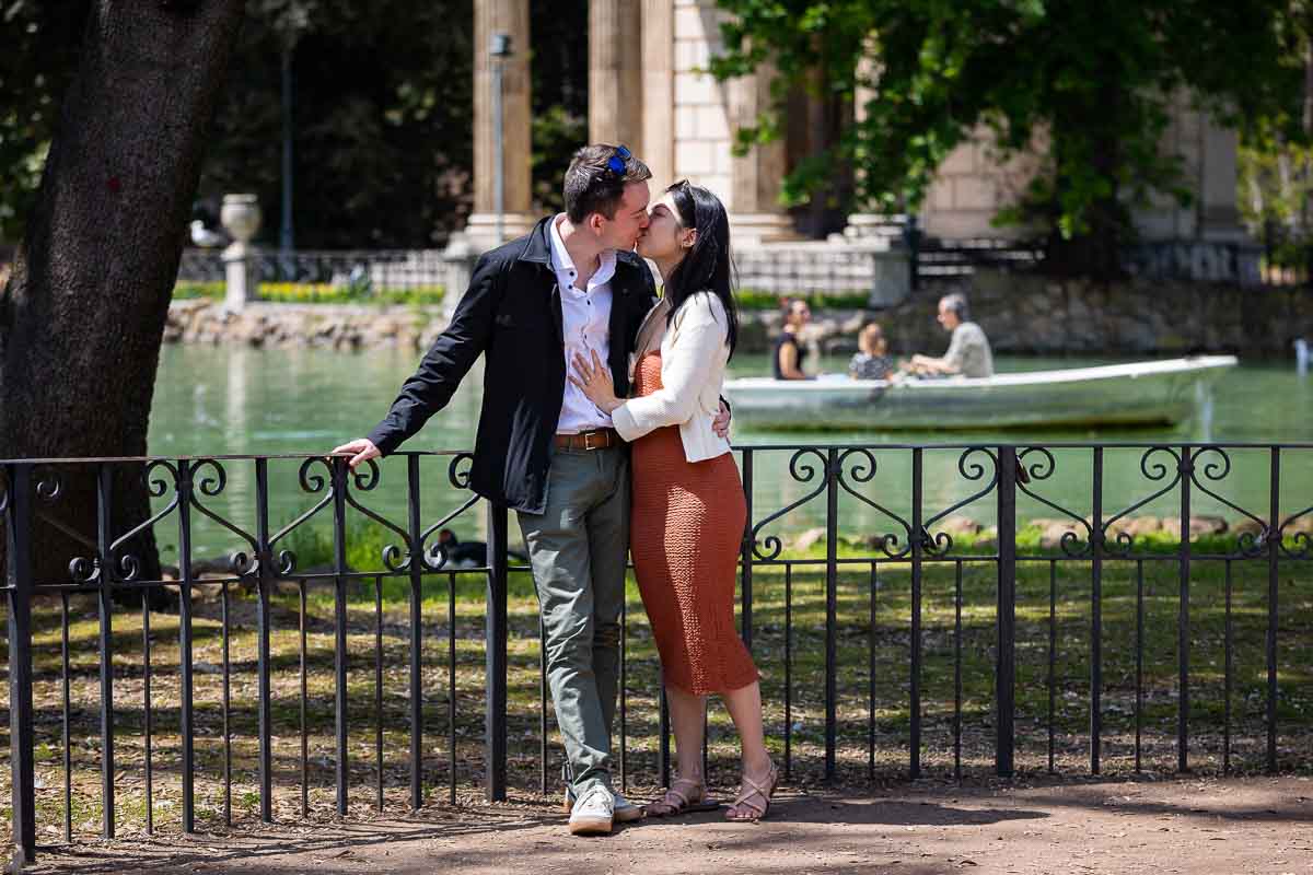 Kissing before the temple during an engagement photoshoot Borghese park 