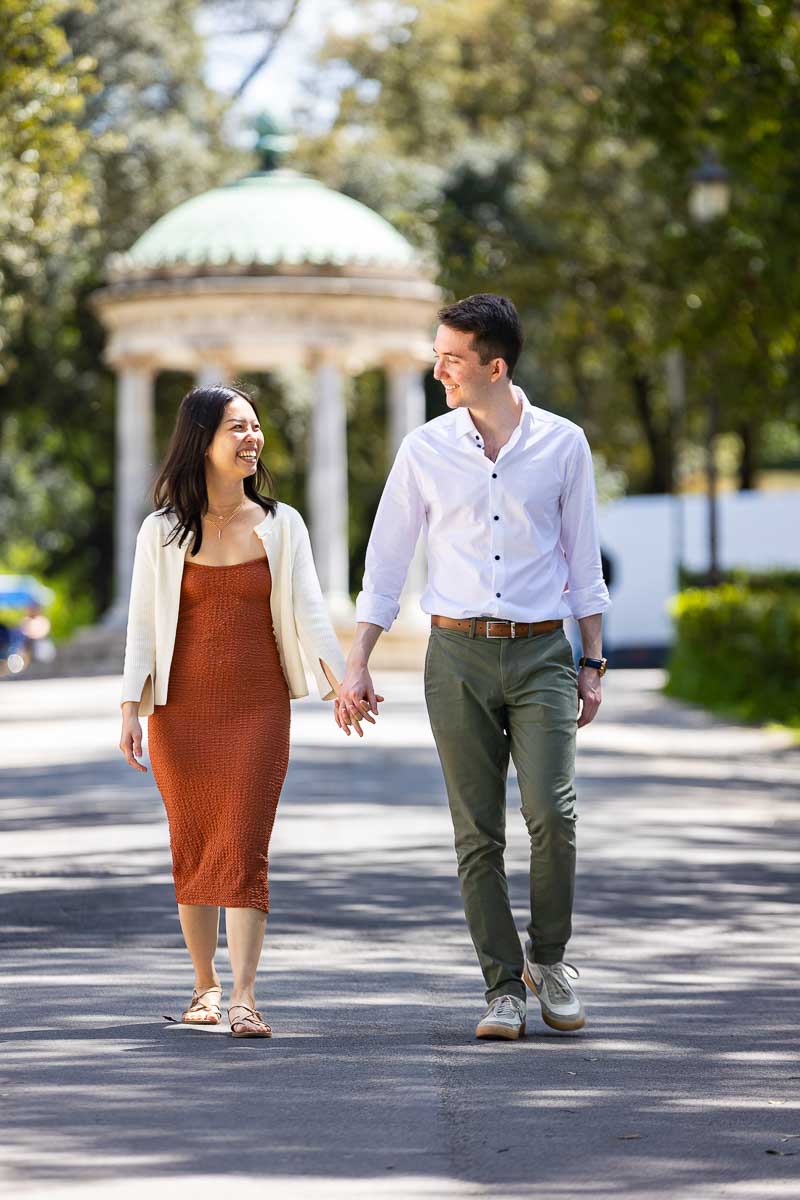 Walking holding hands in hands while on an engagement photoshoot 
