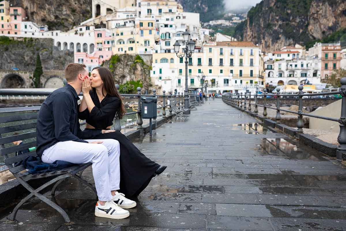 Couple photo shoot sitting down on a bench while taking photos 