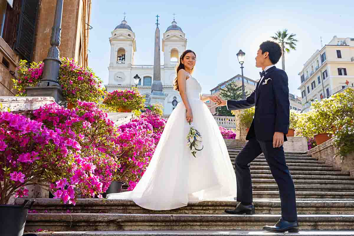 Couple posing steps surrounded by colorful flowers to celebrate spring with a unique and creative photoshoot