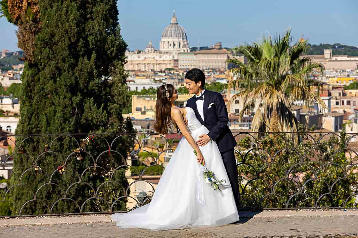 Couple posing in front Saint Peter's dome far distance