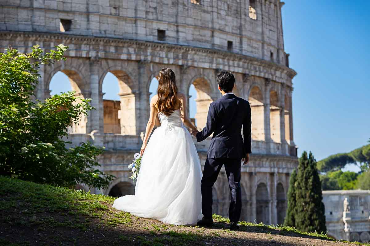 Looking Colosseum during a photography session Eternal city photoshoot with just married couple