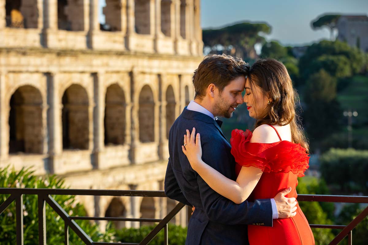 Romantic couple posing forehead to forehead in front Colosseum at dusk