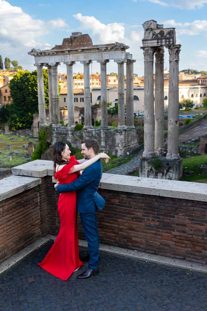 Side posed couple during a photoshoot at Piazza del Campidoglio with an incredible view Roman forum as backdrop