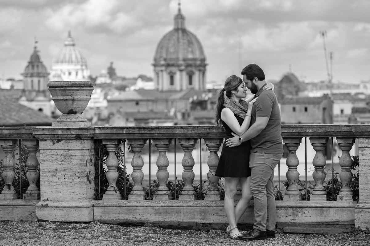 Black and white photography of a couple posing in front roman cityscape during a photo session in Italy
