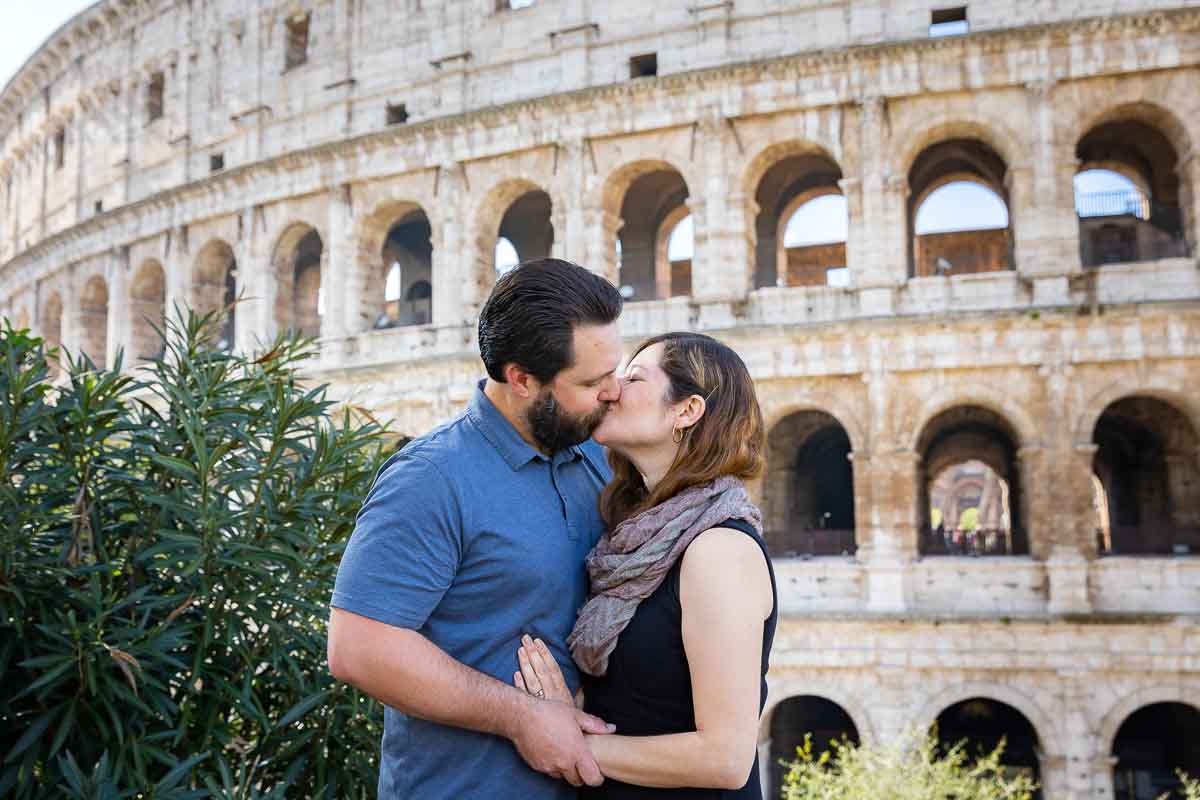 kissing in front Roman Colosseum in Italy