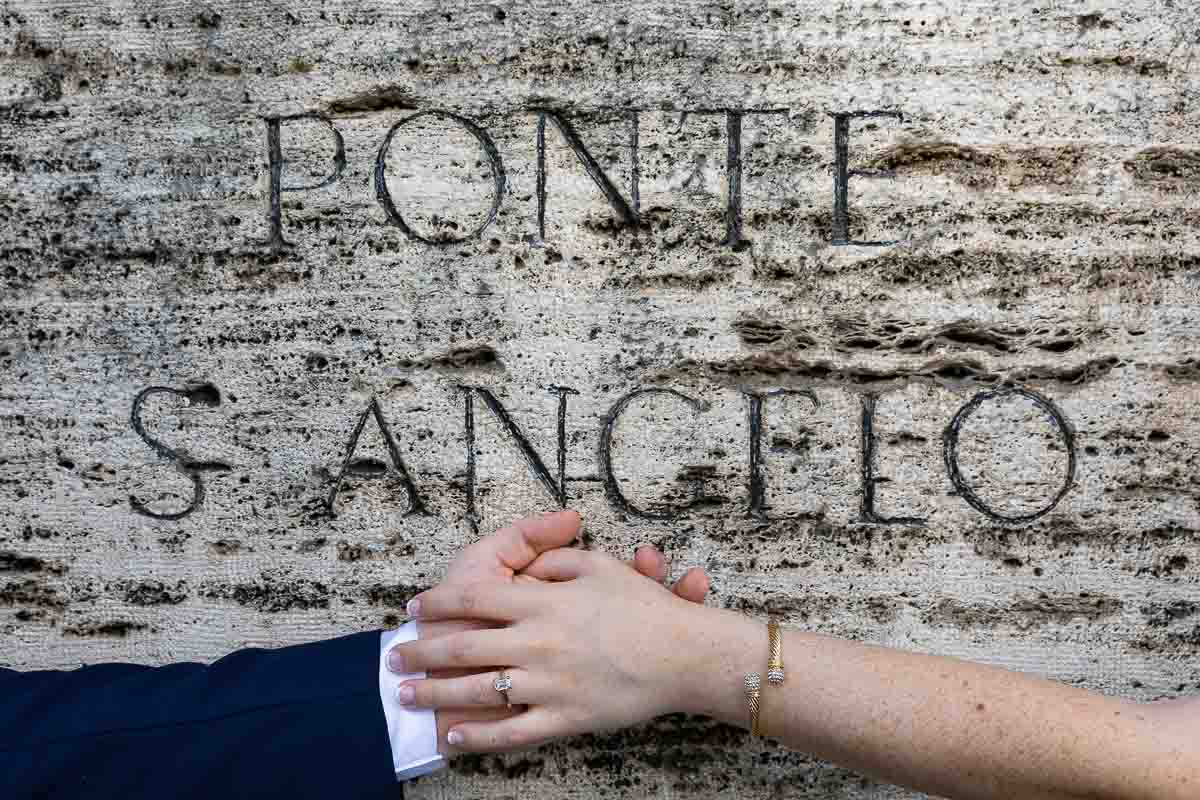 Picture of the engagement ring photographed over the castel sant'angelo ancient stone encryption