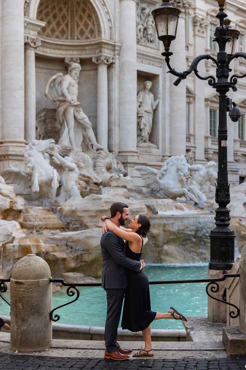 Standing sideways together by the Trevi fountain early morning light