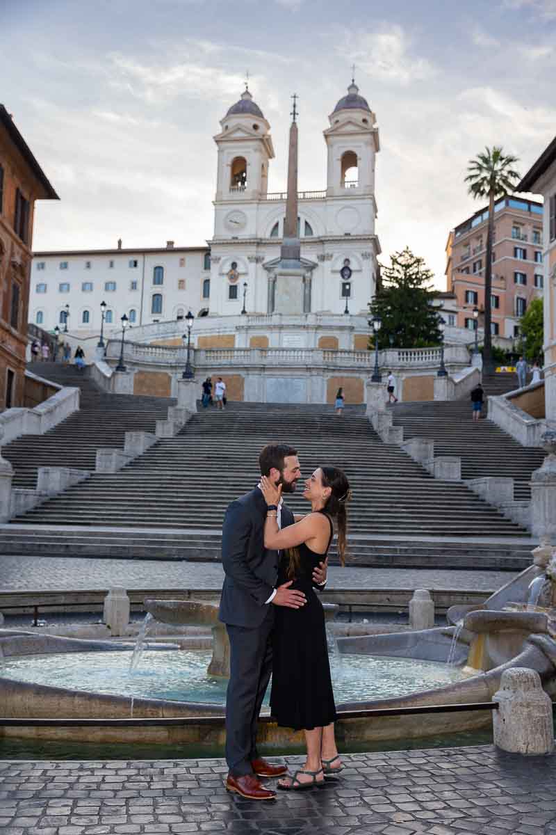 Standing bottom Spanish steps taking engagement pictures 
