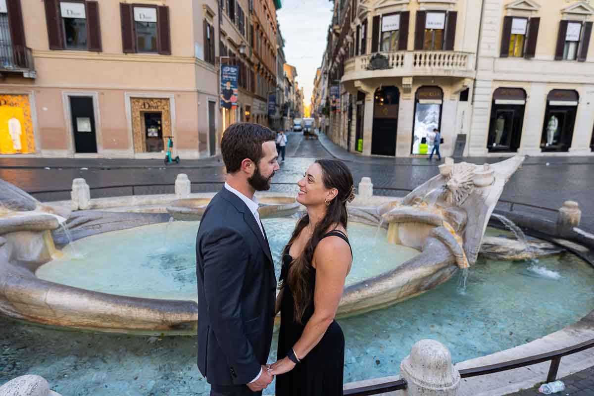 Couple portrait looking at each other bottom of Piazza di Spagna with pictures taken Barcaccia water fountain 